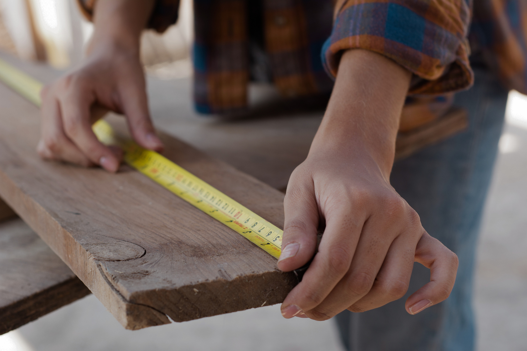 Close-Up Shot of a Carpenter Measuring a Wood Plank